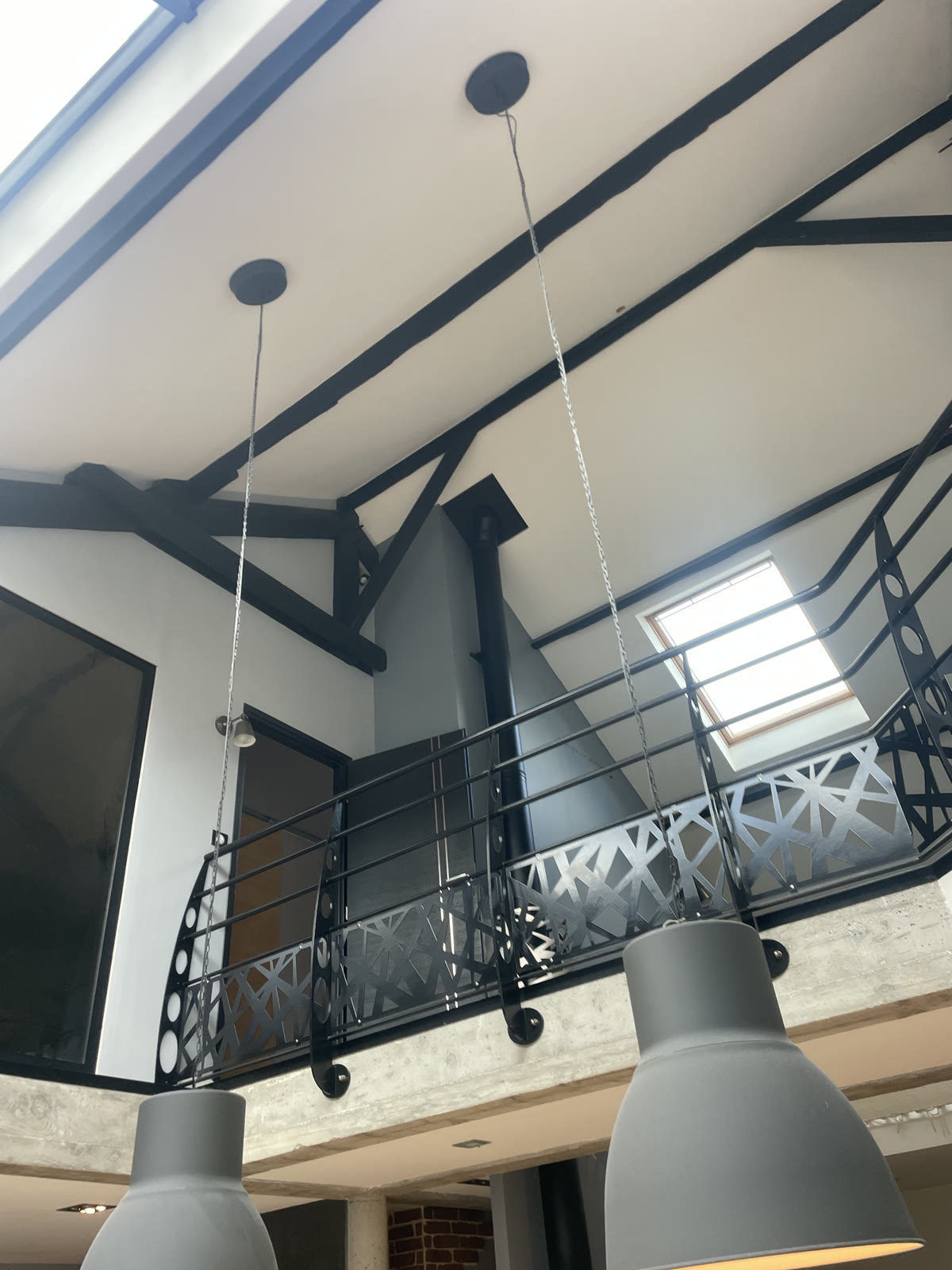 Grand volume intérieur fini avec poutres apparentes, mezzanine et fenêtres de toit